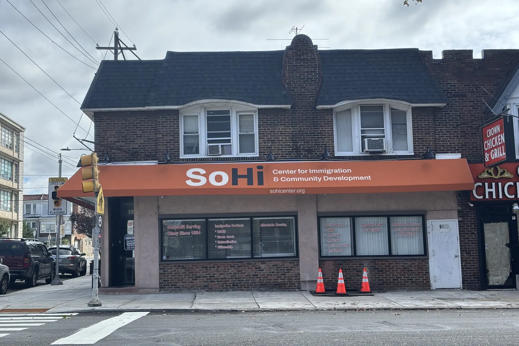 The SoHi Center storefront at 6055 N. 5th St. under its new orange awning reading SoHi Center for Immigration & Community Development.